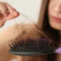 Woman untangling hair from hairbrush