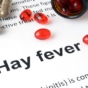 The word hay fever surrounded by pills