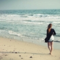 Woman walking on shoreline