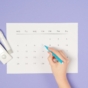 Woman marking date on calendar