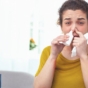 Woman using nasal spray and looking at the camera