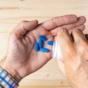 Male holding blue pills