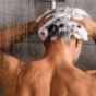 Rear view of man washing hair in the shower