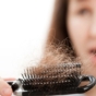Woman noticing hair loss in hair brush