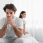 Sad man sitting on edge of bed