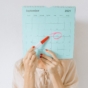 Woman marking date on calendar